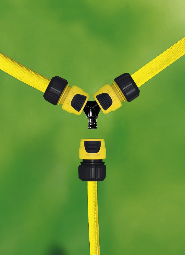Yellow Kärcher hose connectors attached to three hoses against a blurred green background.