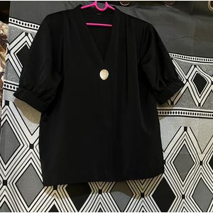Genevieve black blouse featuring a V-neckline and a central button detail, characteristic of women's apparel.
