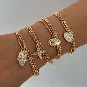 4-Piece Layered Gold Bracelet Set - Charm pendant with Airplane, Heart, Eye & Hand Symbols